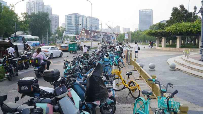 停放秩序治理前，蓝色港湾周边的共享单车潮汐淤积严重，行人通行受阻。北京市交通委供图