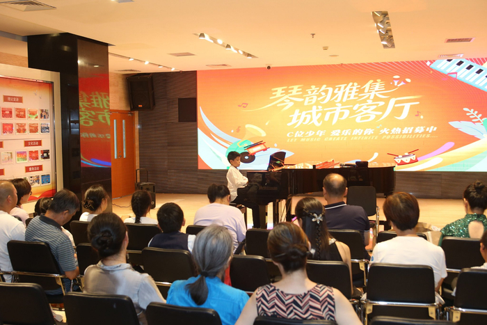 一位少年坐在大厅钢琴前演奏。东城区文化馆供图