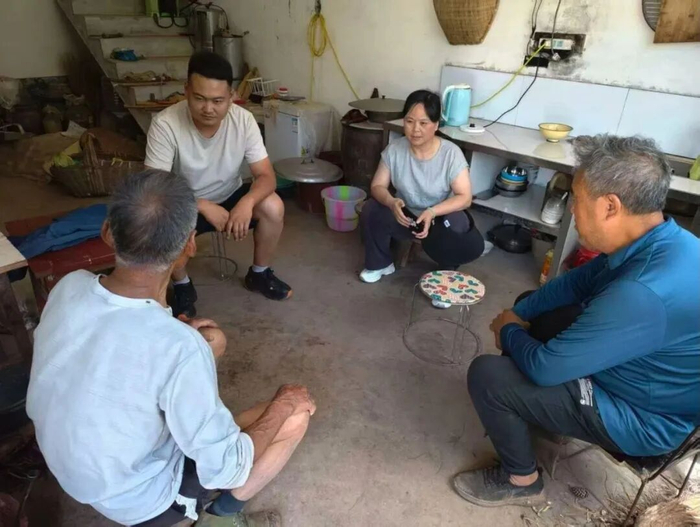 李杨（左二）到村民家中走访。南郑区委宣传部供图
