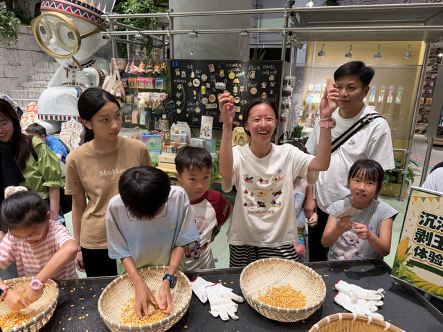 8月8日，百联×世界树之巅主题店” 文博主题沉浸式空间，剥玉米大赛。澎湃新闻记者 邹娟 摄