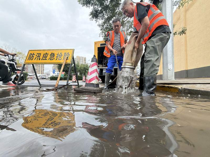 丰台区水务局防汛抢险工作人员正在处理晓月东路个别点位积水。新京报记者 陶冉 摄