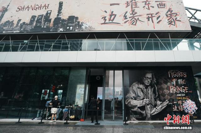 图为“约翰尼·德普：边缘形象”艺术展海报吸引过往观众的目光。中新社记者 张亨伟 摄