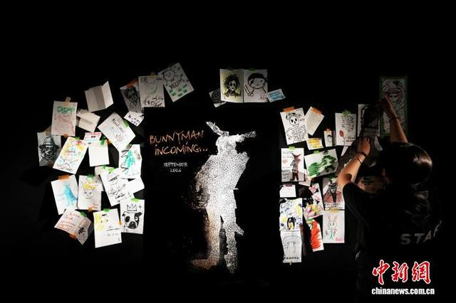图为工作人员正在将观众的留言贴满墙面。中新社记者 张亨伟 摄