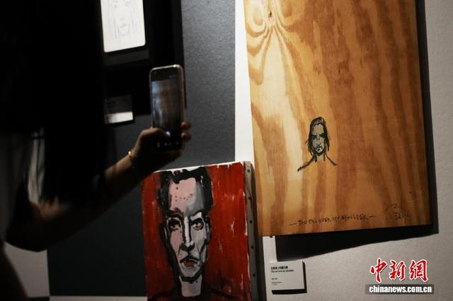 图为观众欣赏约翰尼·德普的自画像《在我肩上的猫头鹰》。中新社记者 张亨伟 