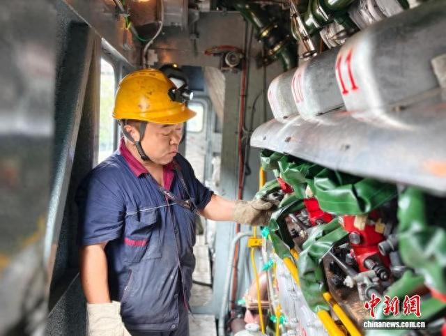 图为聂全喜通过“把脉”了解柴油机喷油泵跳动频率。林馨 摄