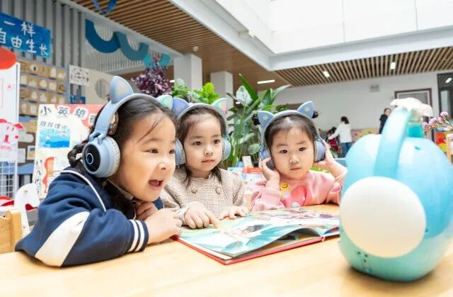 孩子们在智能阅读机的引导下读有声绘本。中国教育报-中国教育新闻网通讯员 翟慧勇 摄