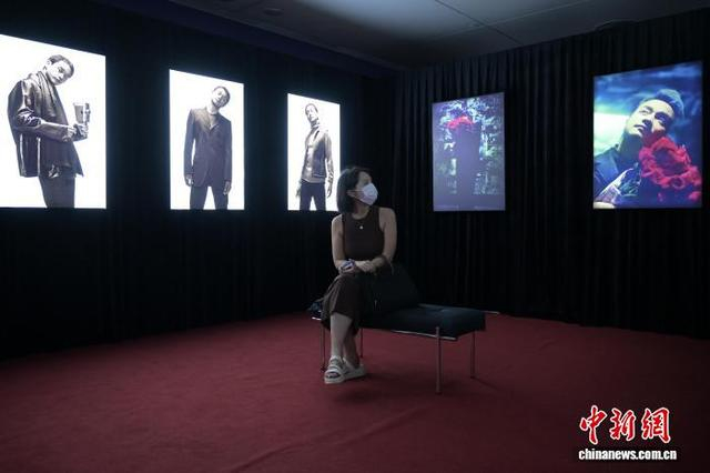 图为一名女士观看展出的张国荣照片。中新网记者 陈永诺 摄