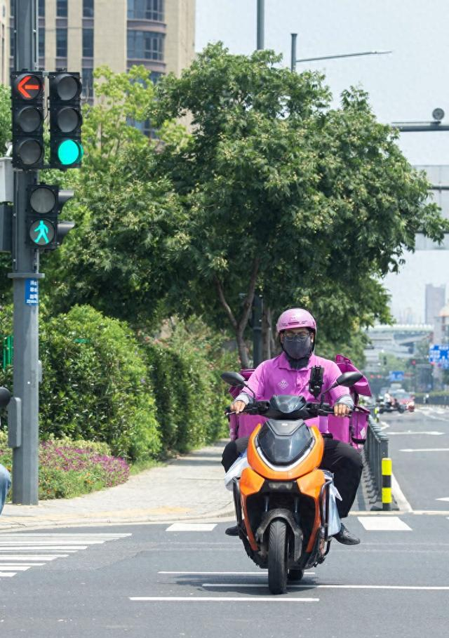  2026年8月17日，在江苏无锡滨湖区鸿桥路与滴翠路交叉路口，外卖骑手按照信号灯有序通行。潘正光摄