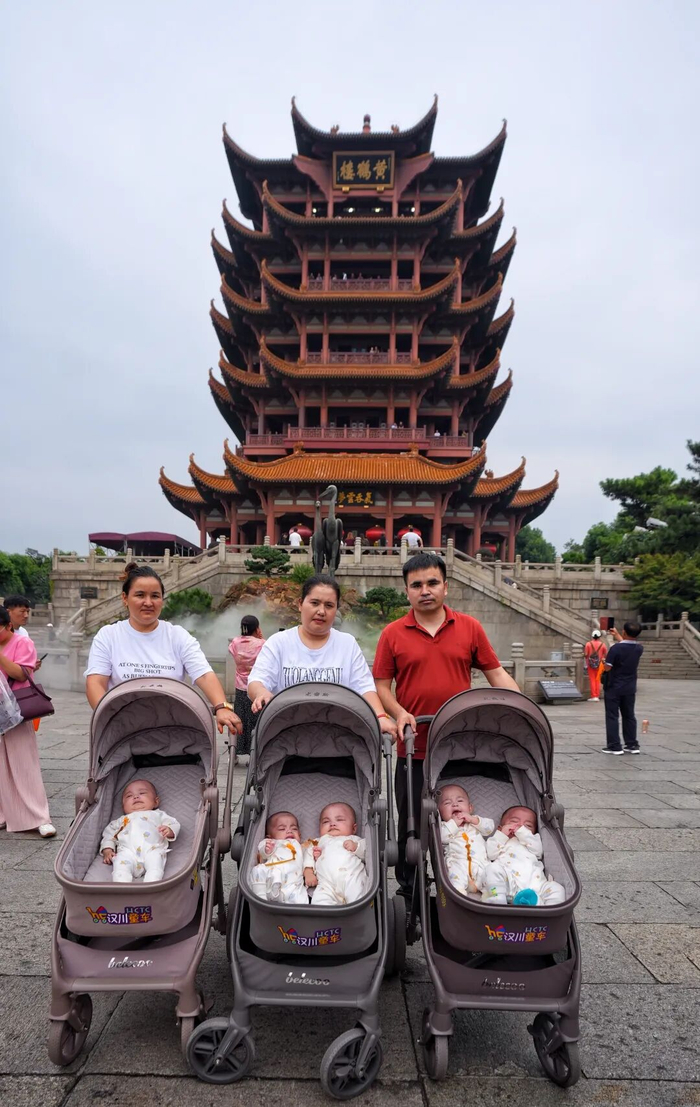 新疆五胞胎的父母和姑姑（后排左一）在黄鹤楼下合影。