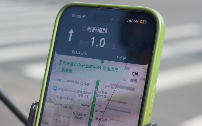 在“红灯停表”试点区域，外卖骑手在路口等候红灯时，系统会自动识别并增加配送时长。新京报记者 王巍 摄