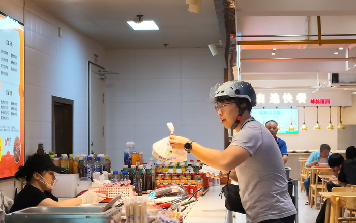 “体验官”在一家餐饮档口取餐。新京报记者 王巍 摄