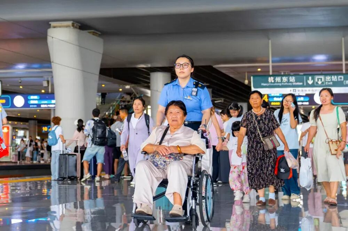 （杭州东站“之江心驿”雷锋服务站工作人员服务重点旅客。祝泰郎 摄）