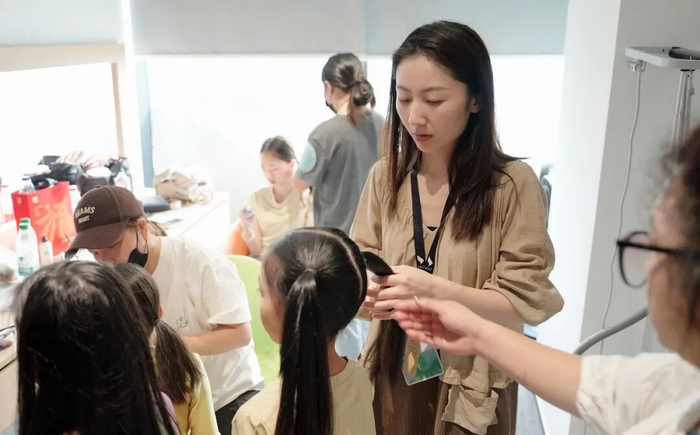 谭淇尹在演出后台为葫芦童声的孩子们妆发（受访者供图）