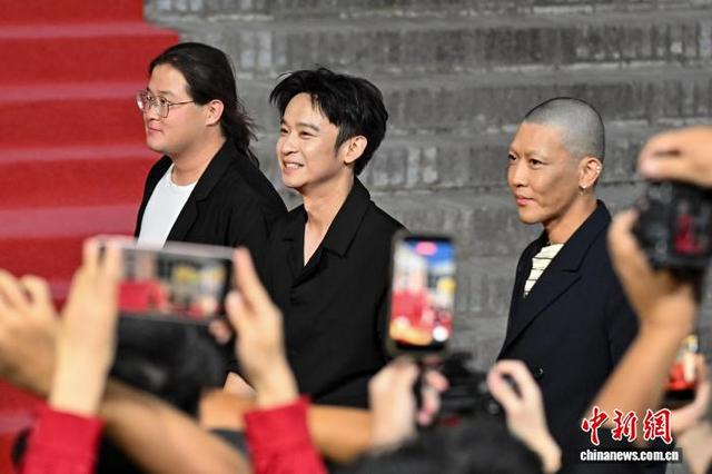 图为“青年评审荣誉”评审主席董子健（中）亮相开幕红毯。中新社记者 韦亮 摄
