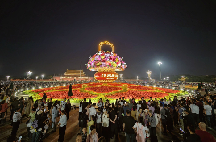 夜晚亮灯的“祝福祖国”大花篮吸引游客拍照。新京报记者 薛珺 摄