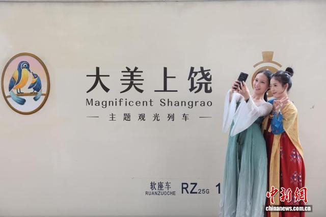 9月27日，江西鹰潭，乘客在“大美上饶”主题观光列车前拍照打卡。中新社记者 刘占昆 摄