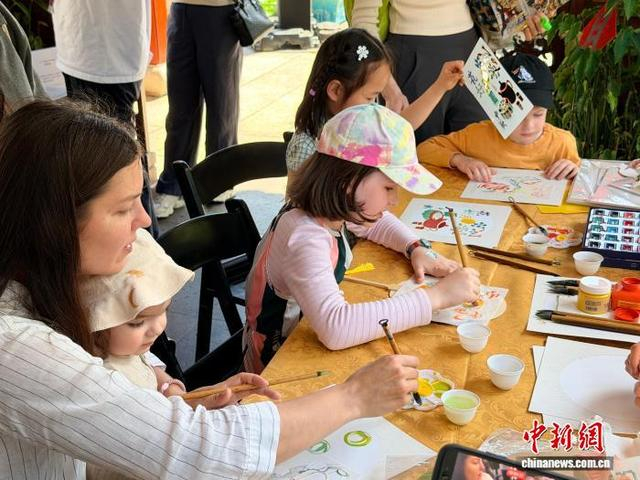 当地时间9月26日，当地民众在“天涯共此时·江海同月明”悉尼中秋游园会上绘画中秋主题扇子。 薄雯雯 摄