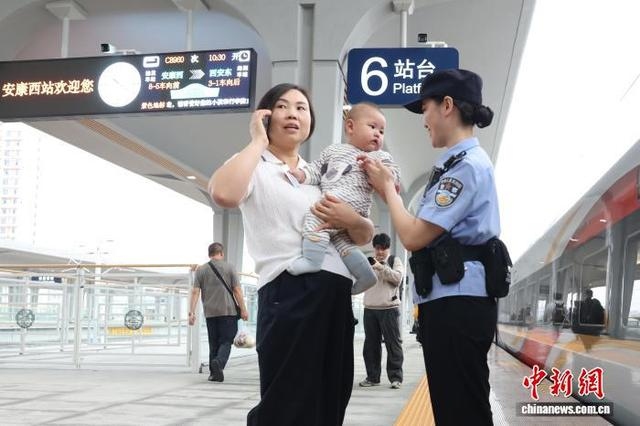 图为乘警在站台上协助乘车旅客。张鑫 摄 