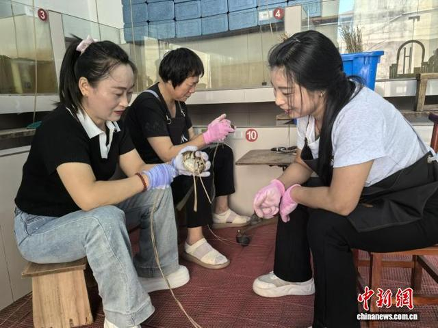 工人们正在捆扎大闸蟹。 中新网记者 钟升 摄