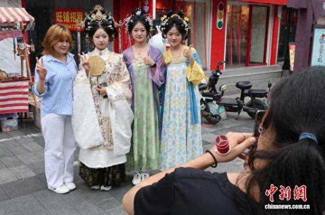 NPC穿古装巡游，与游客拍照互动。赵晓 摄