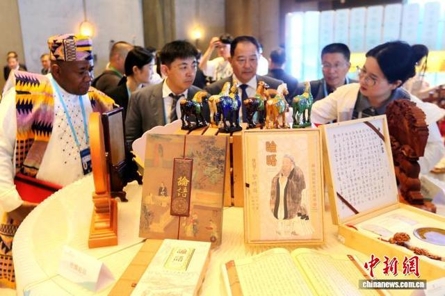 中外嘉宾在尼山世界文明论坛会场外赏鉴文创产品。中新社记者 梁犇 摄