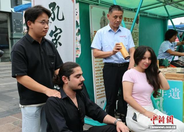 外国留学生在庙会上体验传统艾灸。赵晓 摄