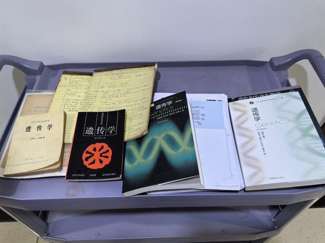 2026年9月下旬，吴燕华向记者展示四版《遗传学》教材。澎湃新闻记者 栾晓娜 摄
