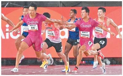 男子4×100米接力决赛，中国队夺冠。图为王胜杰（前右）和谢震业（前左）在比赛中接力。