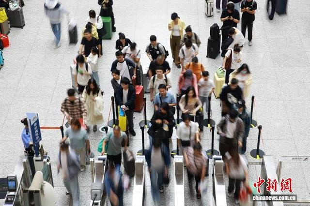 10月1日，旅客在杭州东站检票上车。中新社记者 孙杨洋 摄