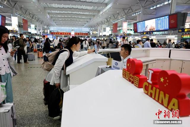 在铁路上海虹桥站问讯台前，工作人员与旅客交流。中新网记者 殷立勤 摄