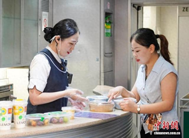 随车餐饮服务员为旅客介绍餐食。李维莉 摄