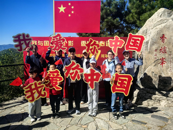 游客在“我与国旗合个影，香山同心送祝福”打卡板前合影留念。北京市公园管理中心供图