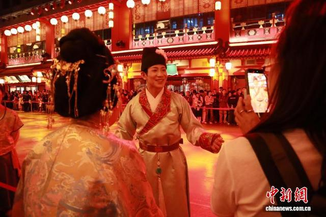 10月1日晚，长安十二时辰主题街区“天街”的演职人员与游人互动。 李一璠 摄