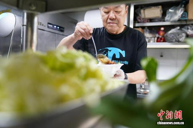 图为9月29日，李兴忠在店内制作卤肉饭。中新社记者 赵宇航 摄 