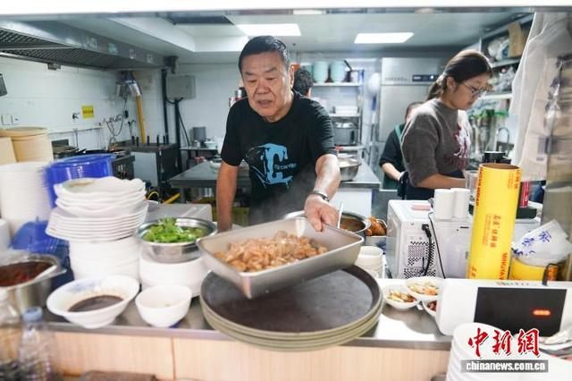 图为9月29日，李兴忠将卤煮出餐。中新社记者 赵宇航 摄 