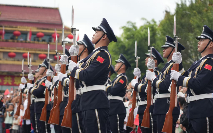 国旗仪仗队沿着国门大道，昂首阔步、踏光前行。瑞丽边检供图