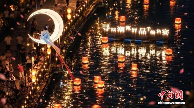 2日，游客尝鲜子梅鱼后，夜间观赏“天女散花”光影表演。主办方 供图