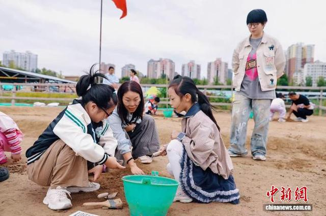 图为游客在郑州商都书院街考古工地体验考古发掘。郑州市文物考古研究院供图