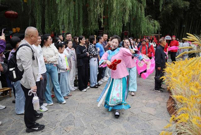 10月3日，在山东省临沂市沂南县竹泉村，游客在观看民俗表演。 新华社发（王彦冰摄）