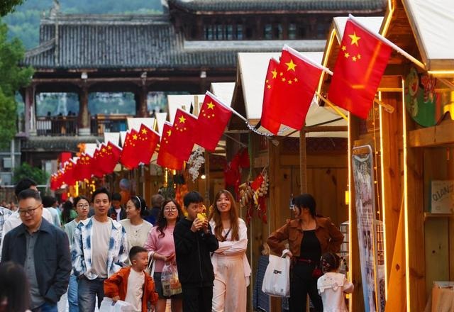 10月2日，游客在重庆市黔江区三岔河武陵水岸长生桥美学市集上游览。 新华社发（杨敏摄）