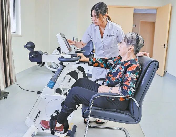 秦皇岛市海港区秦皇燕达金色年华健康养护中心，医护人员带领老年人做康复辅助运动。曹建雄摄