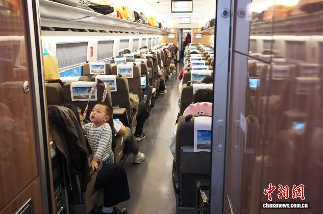 图为10月5日，旅客乘坐G828次高铁列车出行。中新社记者 殷立勤 摄 