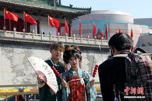 图为游客在西安钟楼前拍照留念。中新社记者 党田野 摄 