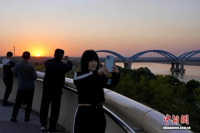 图为黄河落日美景吸引游人驻足拍照。中新社记者 李超庆 摄