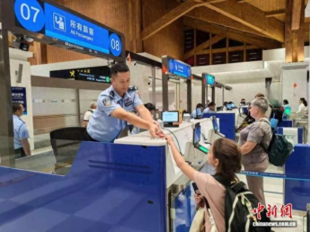 10月5日，三亚凤凰出入境边防检查站执勤民警为通关旅客快速办理边检手续。 张松 摄