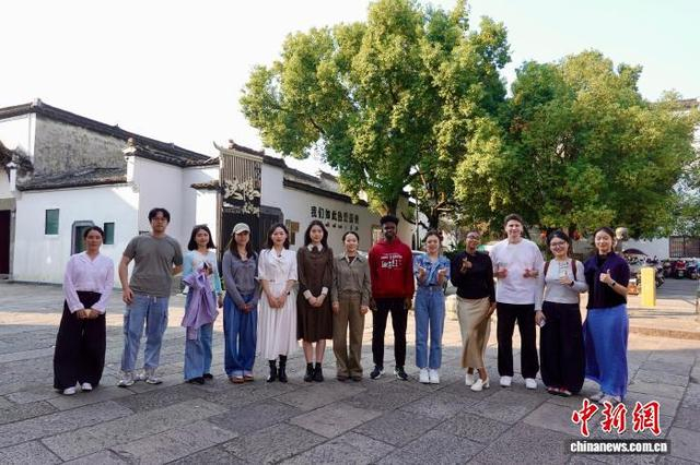 图为10月10日，中外青年在水亭门历史文化街区合照。刘子琳 摄