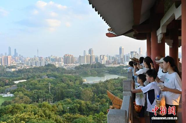 10月11日，广州市天气晴好，游客登上鸿鹄楼观赏湖光山色和广州城景。中新社记者 陈楚红 摄 