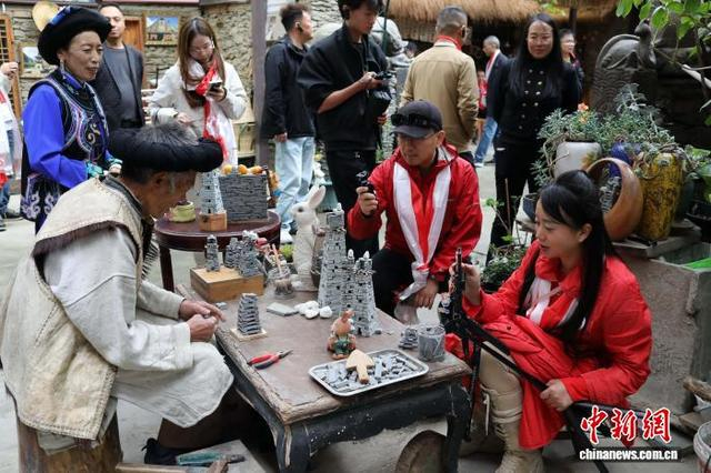 图为桃坪羌寨的老艺人制作微型碉楼吸引海外华媒代表的镜头。中新社记者 王磊 摄