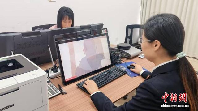 “红石榴”法侨合作工作室内，工作人员对着电脑屏幕做视频调解。 受访者供图