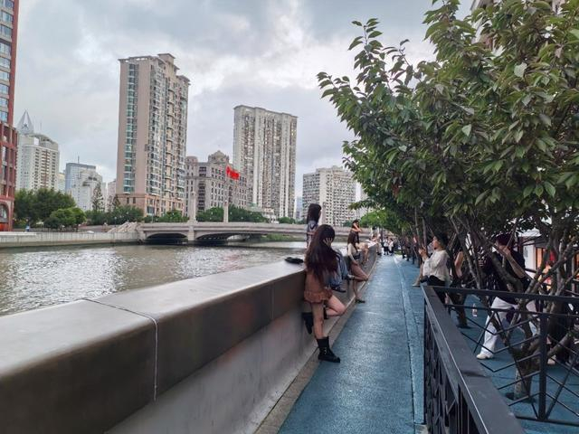 2026年8月28日，夏日天黑得晚，18:30之后很多时尚爱好者在文安路尽头滨河空间打卡对岸的衍庆里时尚中心。赵忞 图
